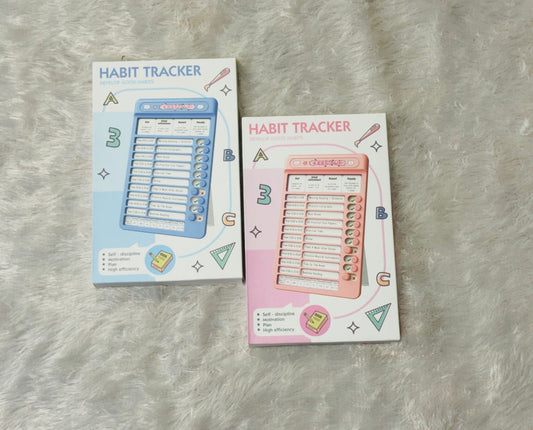 Blue and pink habit tracker boards lying together on a soft rug