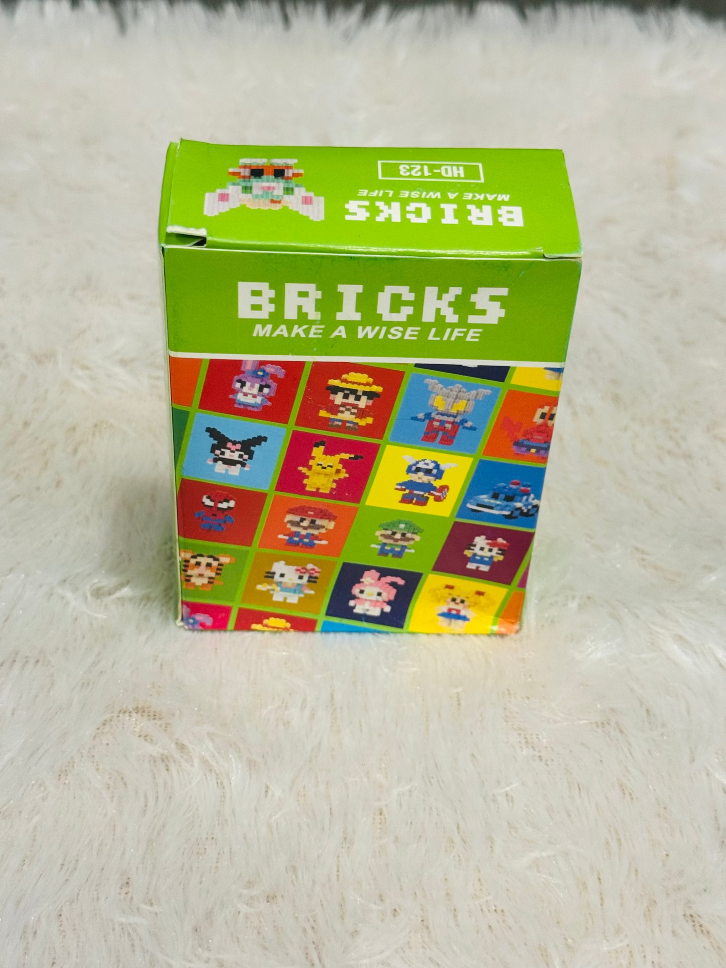 Green bricks block box showing a printed character grid on the front
