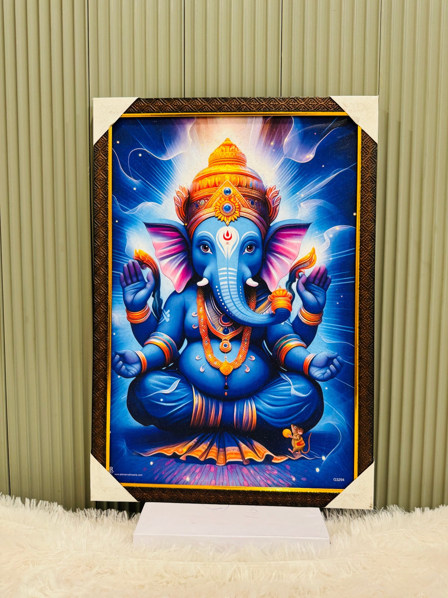 Golden framed Ganesha wall painting in blue tones on a display stand