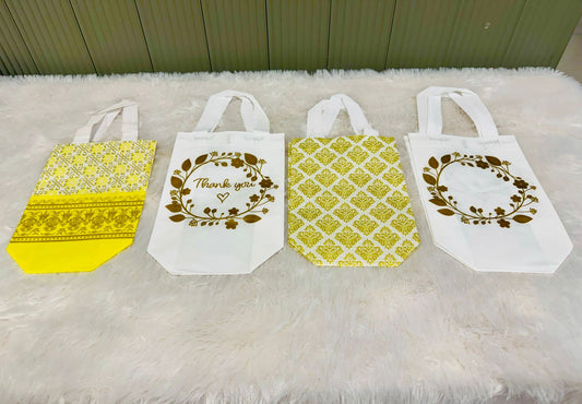 Four small gift bags in white and yellow with printed patterns