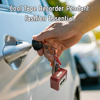 Hand holding car keys with a red tape recorder keychain attached