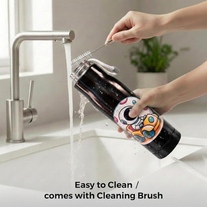Hands cleaning the black 550ml bottle under a running tap with a brush