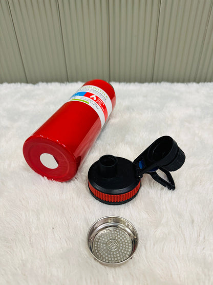 Red 800ml bottle lying down beside its lid and steel strainer