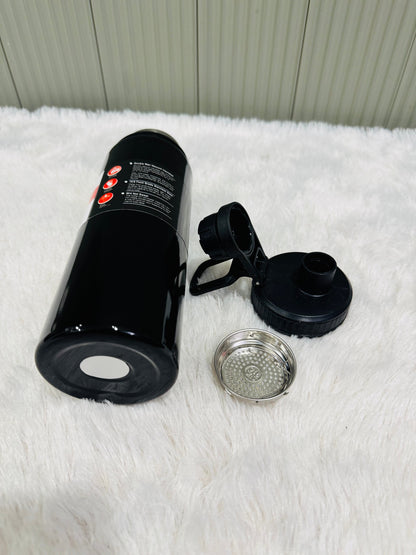 Black 800ml bottle lying down beside its lid and steel strainer