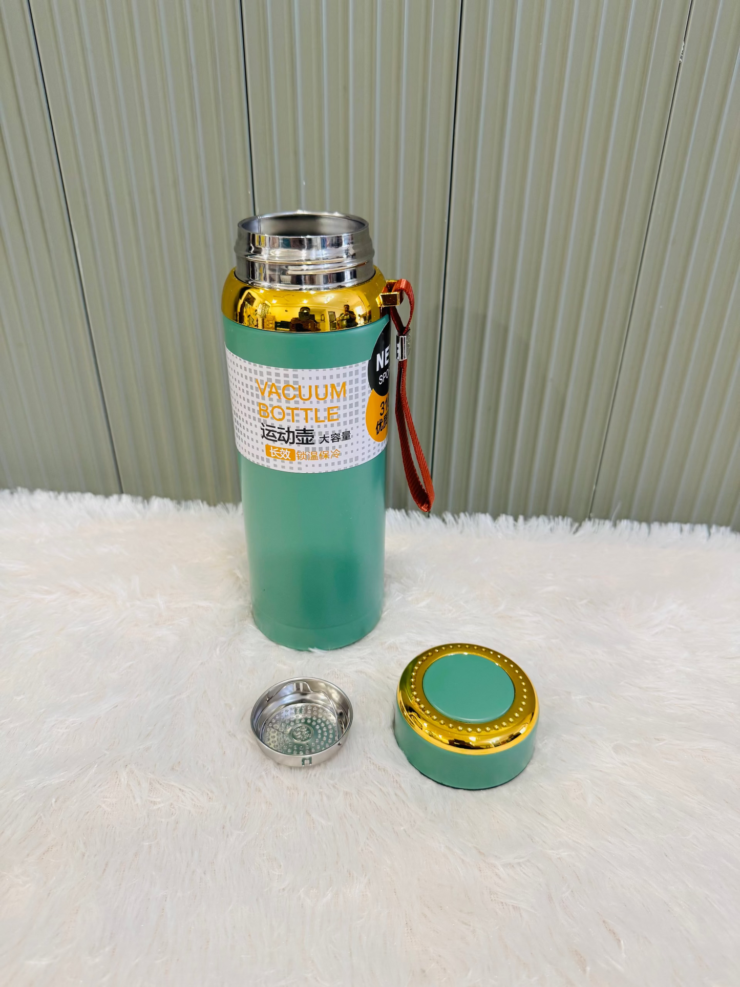 Green 800ml flask standing beside its cup lid and steel strainer