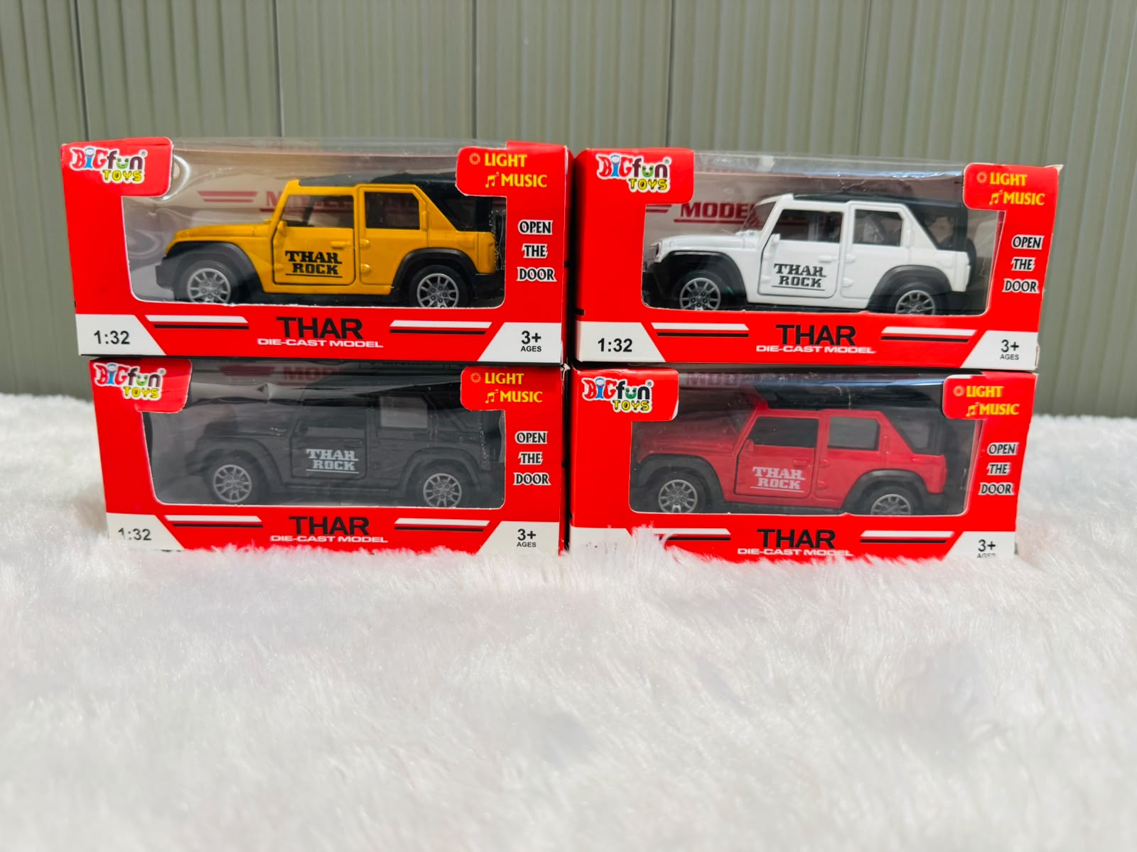 Four boxed 1:32 die cast toy cars with light and music labels
