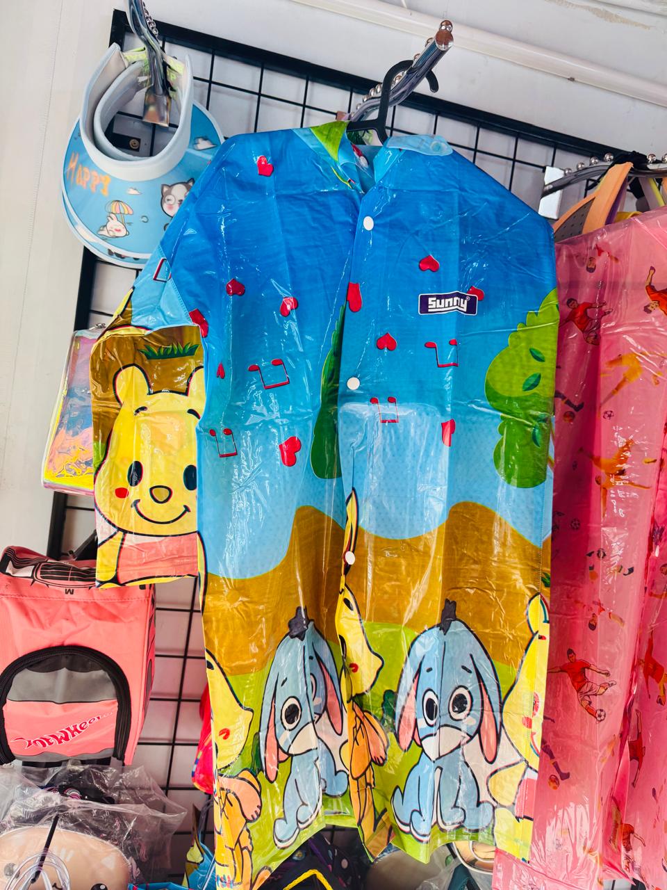Blue and yellow cartoon print kids raincoat with hood, hanging