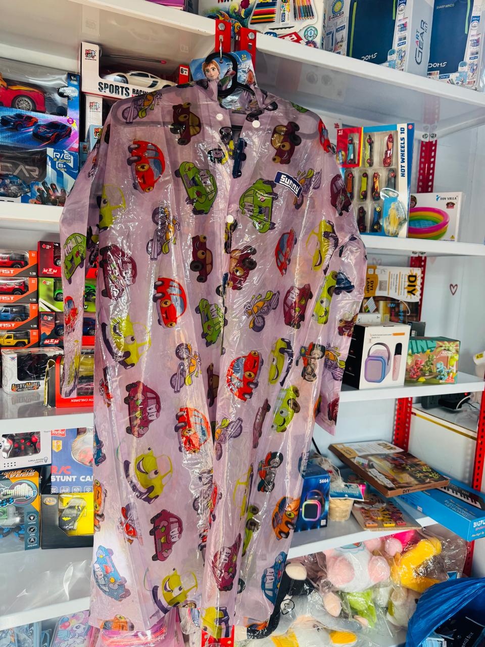 Lilac cartoon character print kids raincoat hanging in a shop