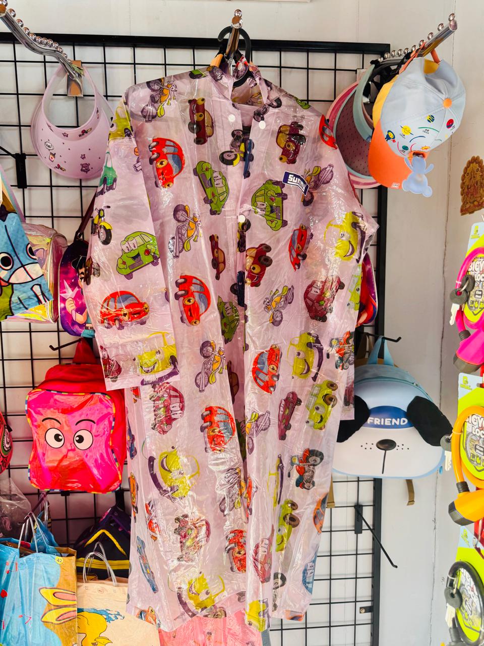 Pink cartoon character print kids raincoat on a shop display grid