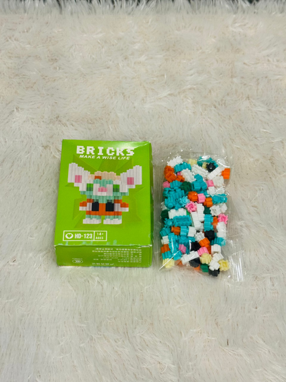 Green bricks block box beside a bag of loose teal building pieces