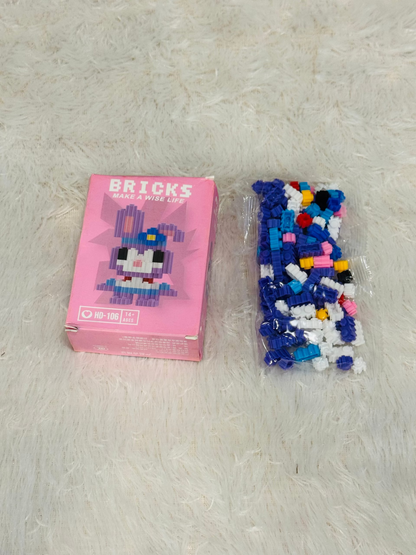 Pink bricks block box beside a bag of blue and white building pieces