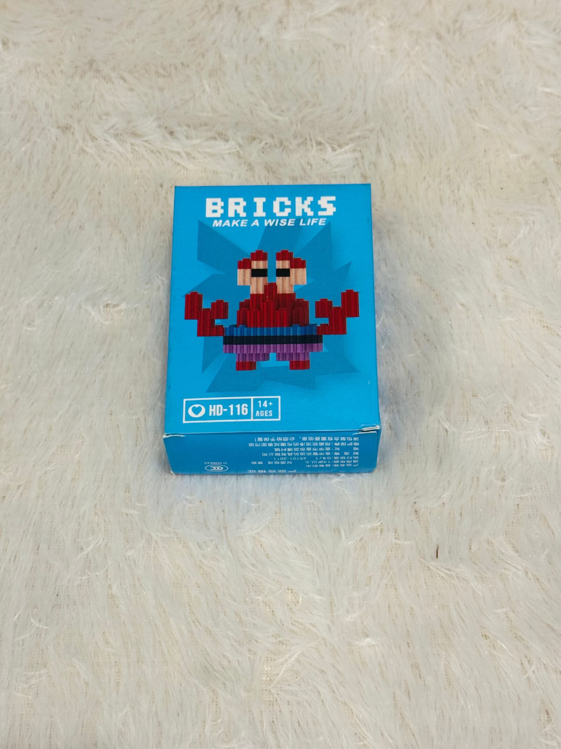 Blue bricks block box with a red crab style mini figure design