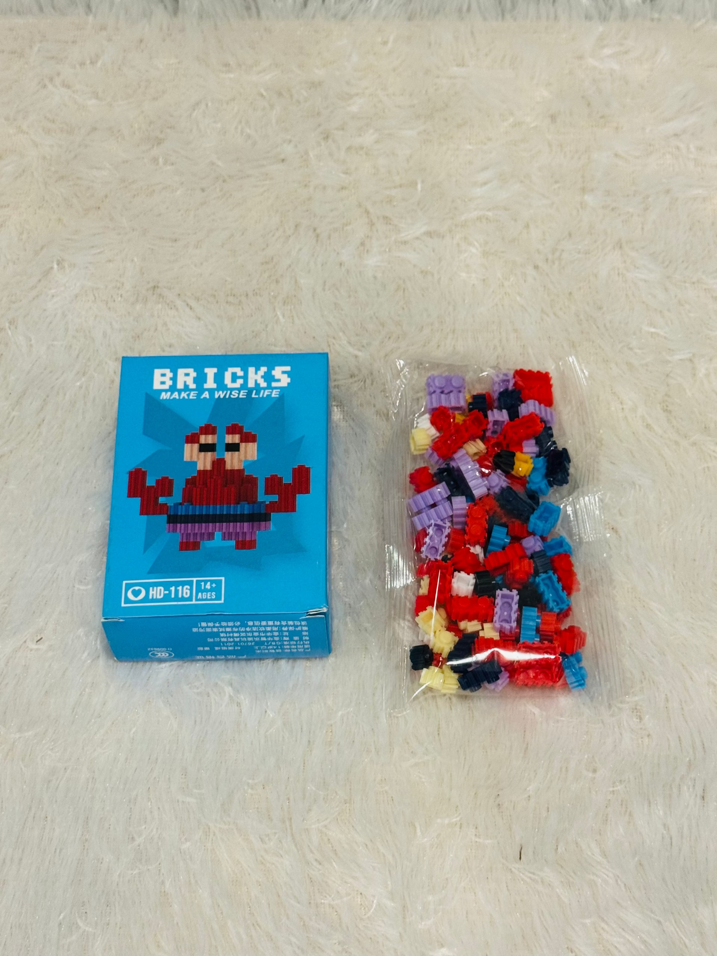 Blue bricks block box beside a bag of loose multicoloured building pieces