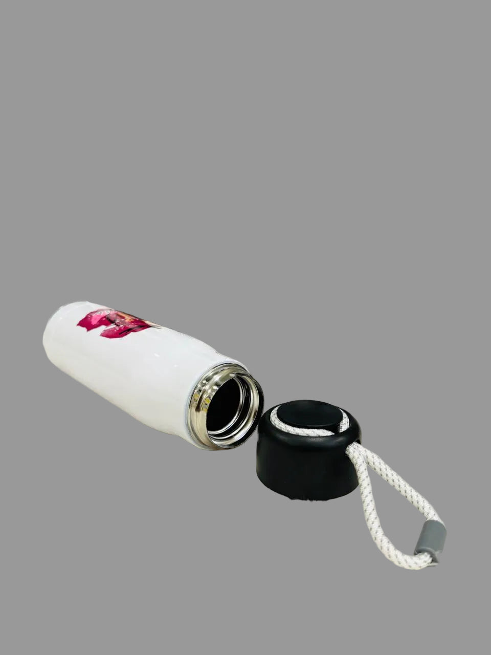 White 550ml cartoon print bottle lying down with its black lid